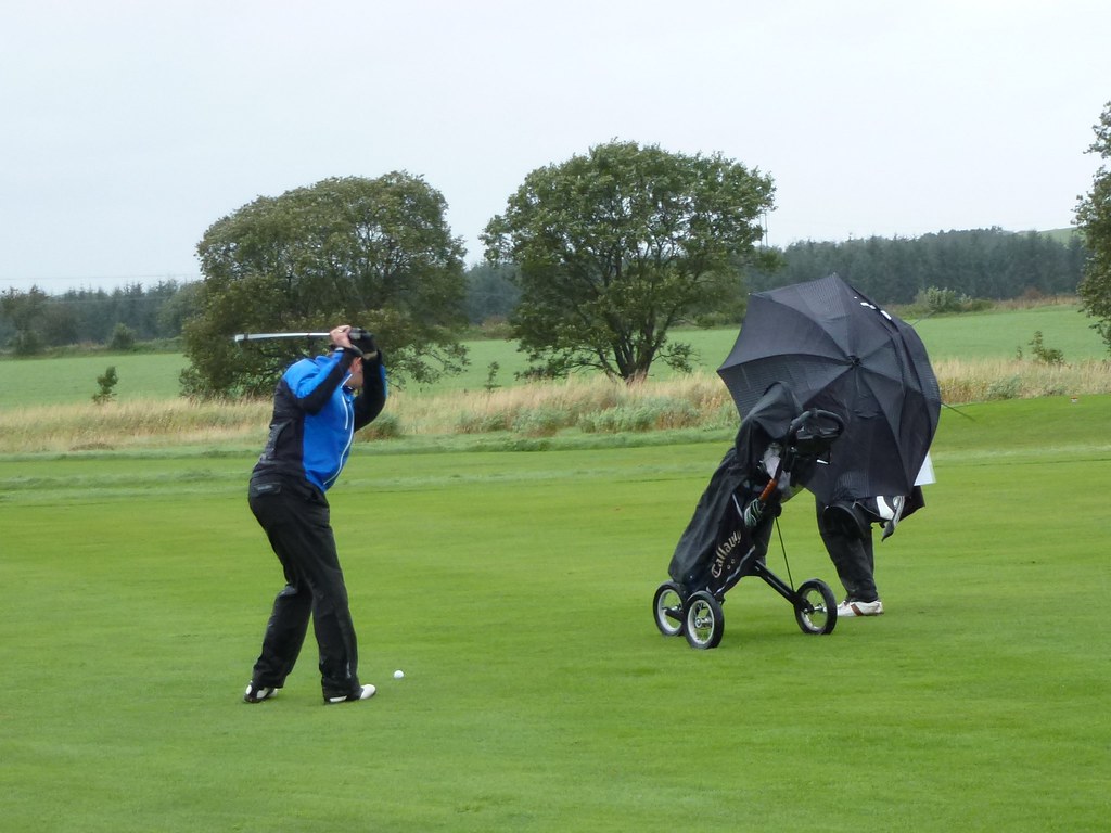 Hombre jugando a golf con lluvis - comparativa de las mejores bolsas de golf para lluvia 2023