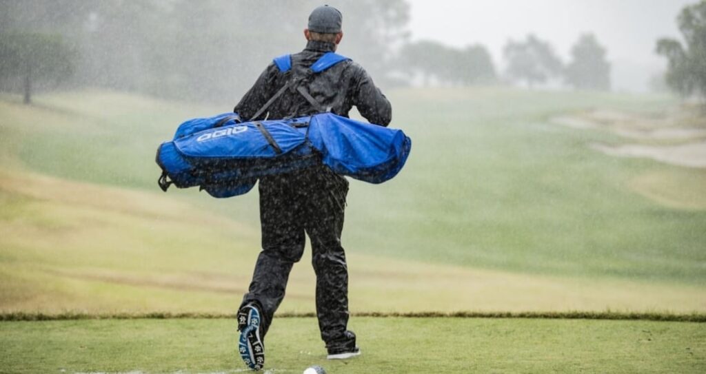 Hombre con bolsa de golf impermeable - top bolsas de palos de golf para dias de lluvia